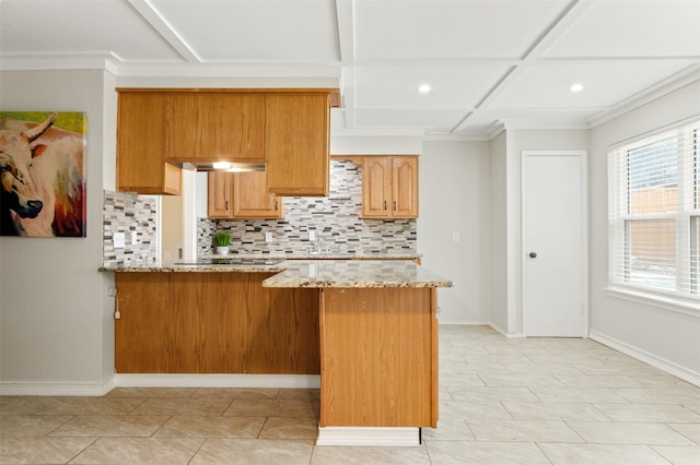 kitchen featuring light tile patterned flooring, coffered ceiling, light stone counters, tasteful backsplash, and kitchen peninsula