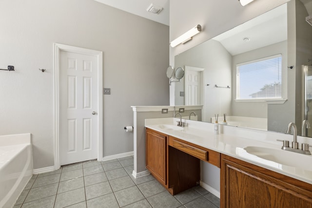 bathroom with vanity, vaulted ceiling, tile patterned floors, and a tub to relax in