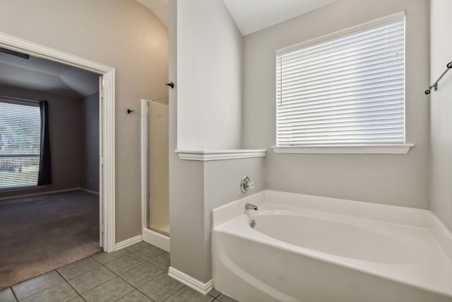 bathroom with a healthy amount of sunlight, separate shower and tub, and tile patterned flooring