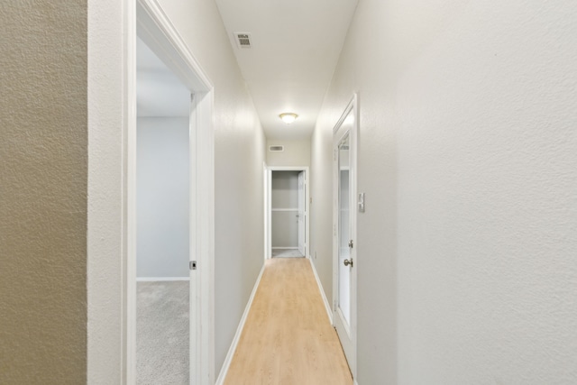 corridor with light hardwood / wood-style flooring