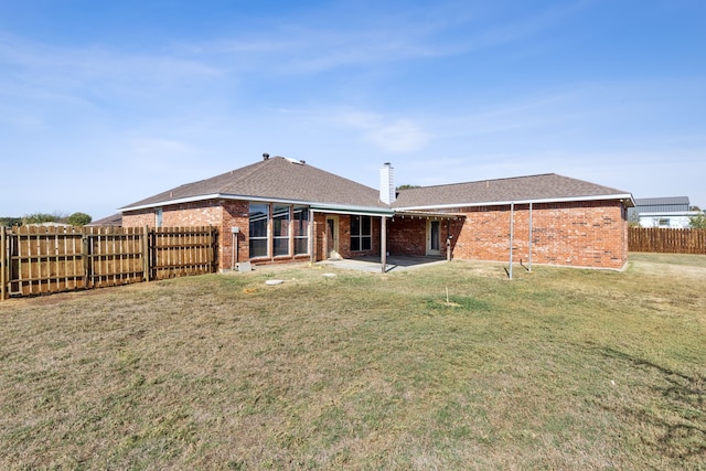 rear view of property featuring a patio area and a lawn