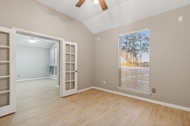 unfurnished room with vaulted ceiling, light hardwood / wood-style floors, french doors, and ceiling fan