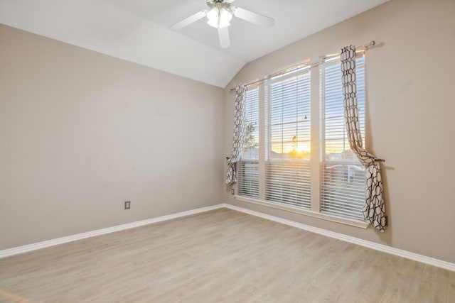 empty room with ceiling fan, lofted ceiling, and light hardwood / wood-style flooring