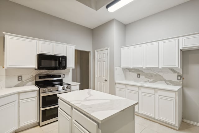 kitchen with white cabinetry, double oven range, and tasteful backsplash