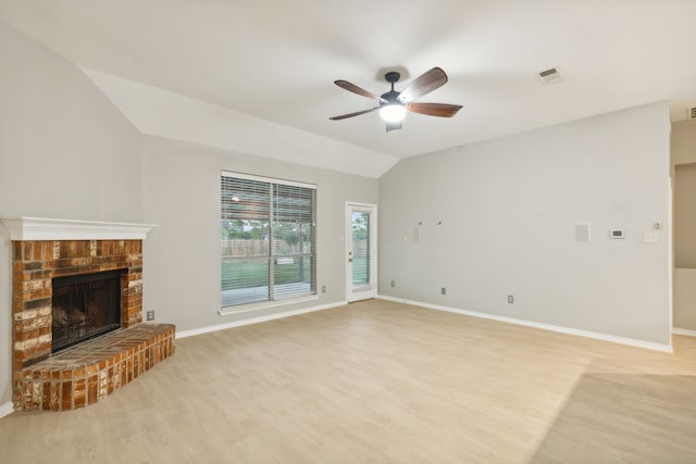 unfurnished living room featuring ceiling fan, lofted ceiling, light hardwood / wood-style floors, and a brick fireplace