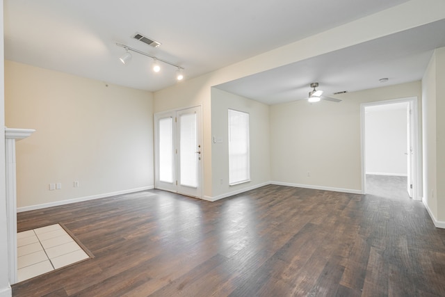 unfurnished living room with ceiling fan, dark wood-type flooring, and track lighting