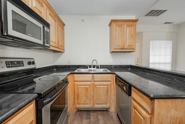 kitchen with dark stone counters, sink, dark wood-type flooring, and appliances with stainless steel finishes