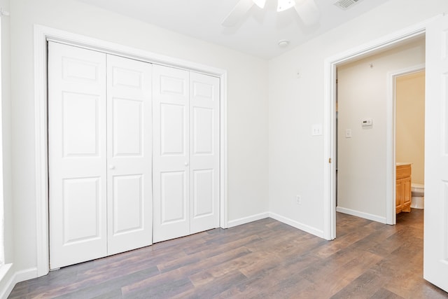 unfurnished bedroom with ceiling fan, dark wood-type flooring, and a closet