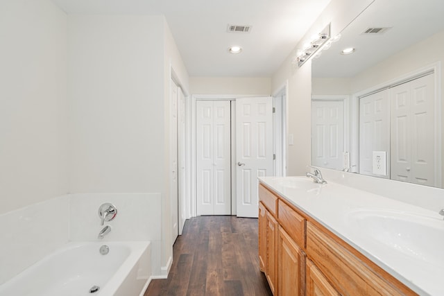 bathroom with a tub, vanity, and hardwood / wood-style flooring