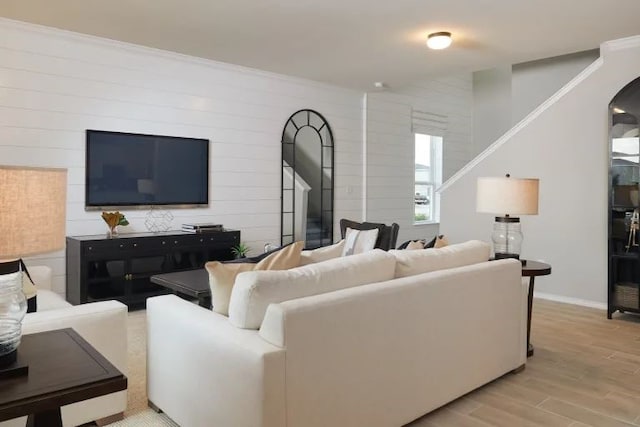 living room featuring crown molding and light hardwood / wood-style flooring