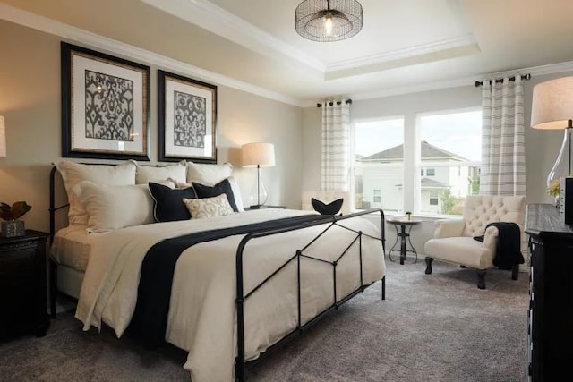 carpeted bedroom with a tray ceiling and crown molding