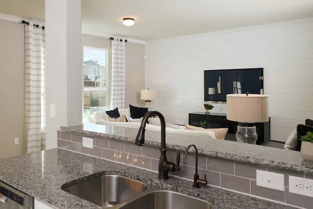 kitchen with stone counters, dishwasher, sink, and a healthy amount of sunlight