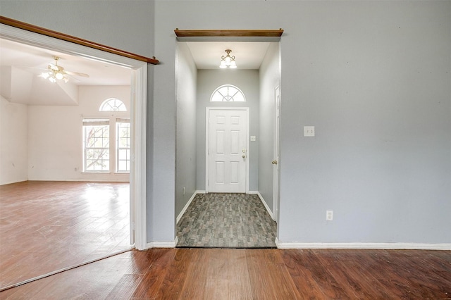 entryway featuring ceiling fan with notable chandelier and wood-type flooring