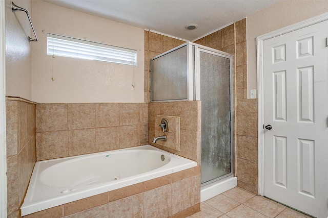 bathroom featuring plus walk in shower, a textured ceiling, tile patterned floors, and tile walls