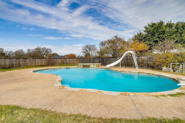 view of swimming pool featuring a diving board and a water slide