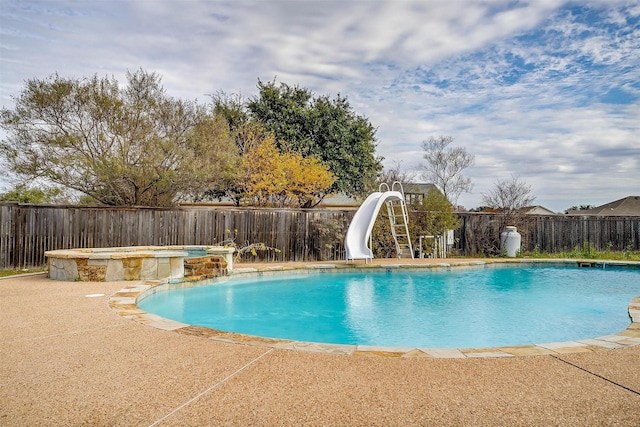 view of pool featuring an in ground hot tub, pool water feature, a patio, and a water slide