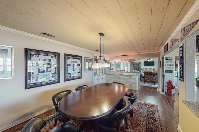 dining space featuring dark wood-type flooring, crown molding, and wooden ceiling