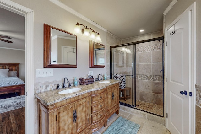 bathroom featuring ceiling fan, vanity, walk in shower, and ornamental molding