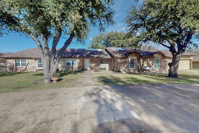 single story home featuring a front lawn and a garage