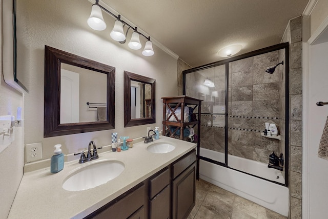 bathroom featuring combined bath / shower with glass door, vanity, ornamental molding, and a textured ceiling