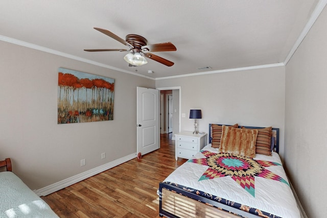 bedroom with ceiling fan, wood-type flooring, and crown molding