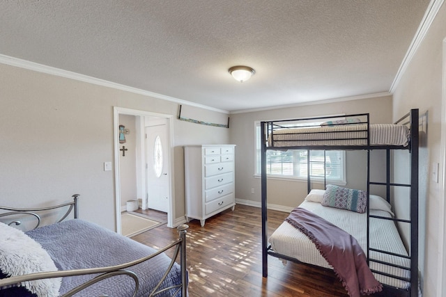 bedroom with a textured ceiling, ornamental molding, and dark hardwood / wood-style floors