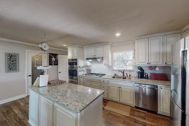 kitchen with light stone countertops, stainless steel appliances, sink, dark hardwood / wood-style floors, and ornamental molding