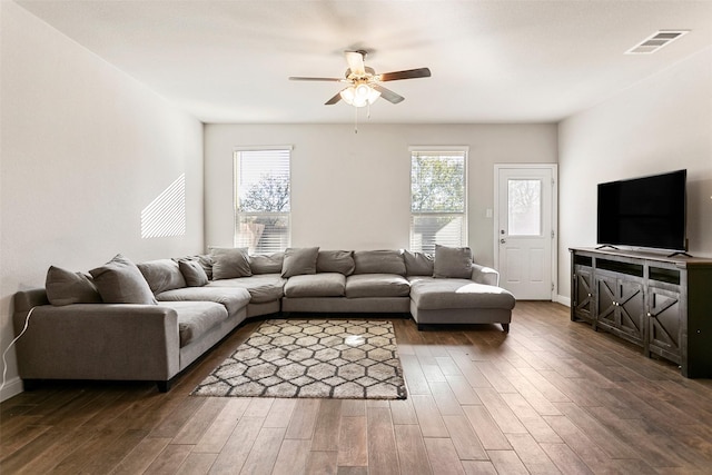 living room with ceiling fan and dark wood-type flooring