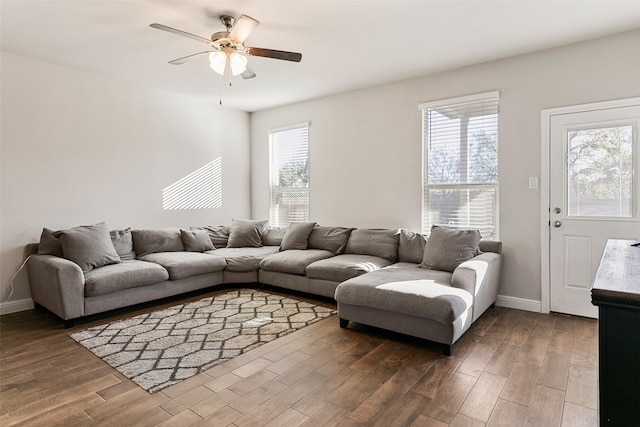 living room featuring ceiling fan and dark wood-type flooring