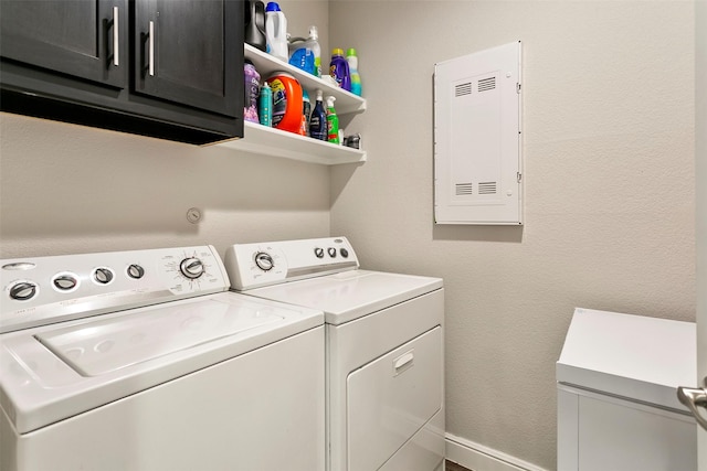 laundry area featuring cabinets, separate washer and dryer, and electric panel