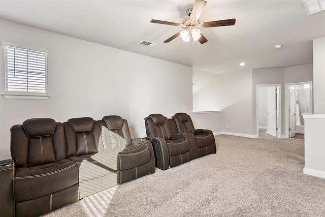 home theater with ceiling fan and light colored carpet