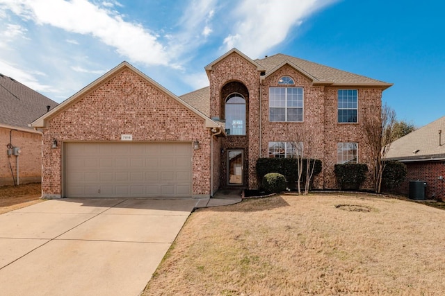 view of front of home with central AC unit, a garage, brick siding, driveway, and a front yard