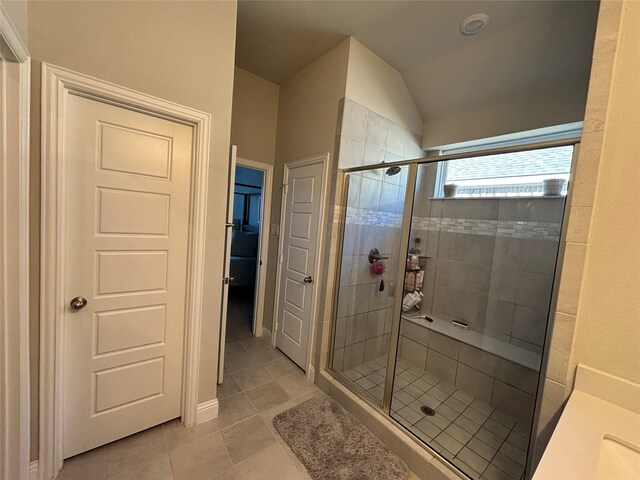 bathroom featuring vanity, vaulted ceiling, tile patterned floors, and an enclosed shower