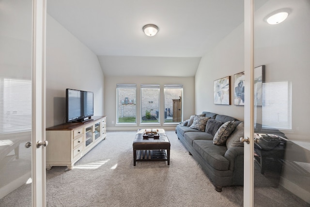 carpeted living room featuring lofted ceiling and french doors