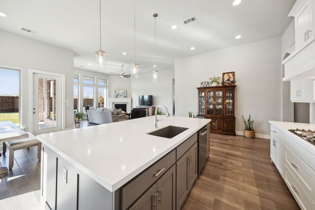 kitchen featuring white cabinetry, stainless steel dishwasher, dark wood-type flooring, and sink