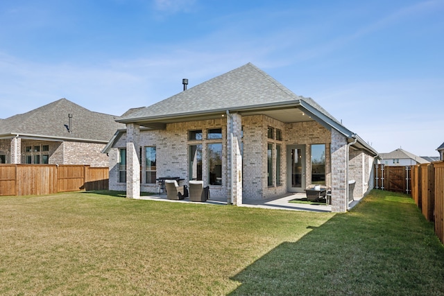 back of property with a yard and a patio