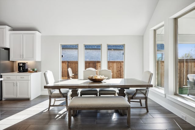 dining space with dark hardwood / wood-style floors and lofted ceiling