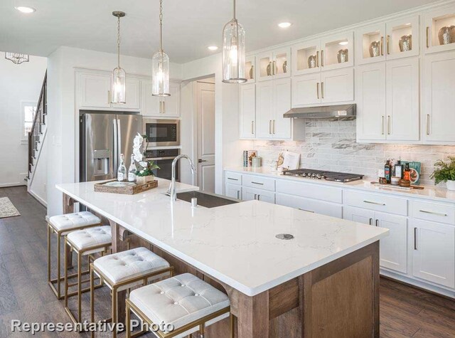 kitchen with white cabinetry, a center island with sink, stainless steel appliances, and sink