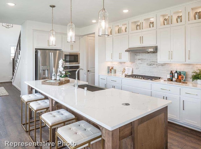 kitchen featuring an island with sink, sink, white cabinets, and black appliances