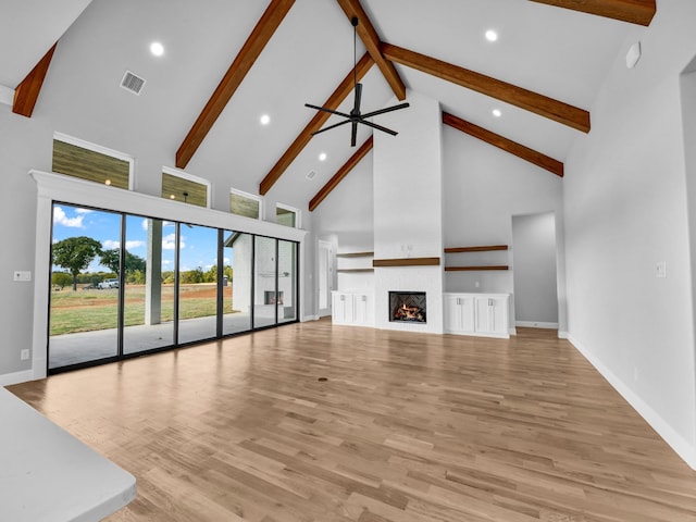 unfurnished living room with beam ceiling, ceiling fan, high vaulted ceiling, and light wood-type flooring