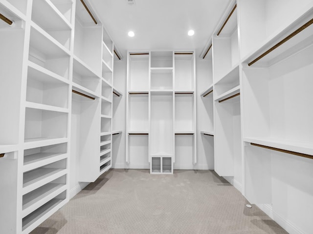 walk in closet with light carpet