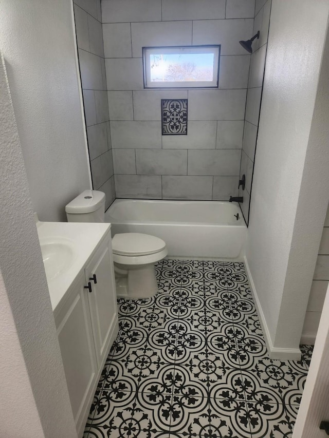 full bathroom featuring tile patterned floors, tiled shower / bath, vanity, and toilet