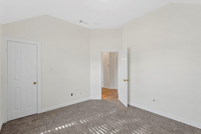 carpeted spare room featuring lofted ceiling