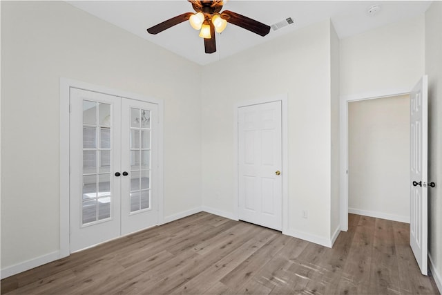 spare room with ceiling fan, light hardwood / wood-style floors, and french doors