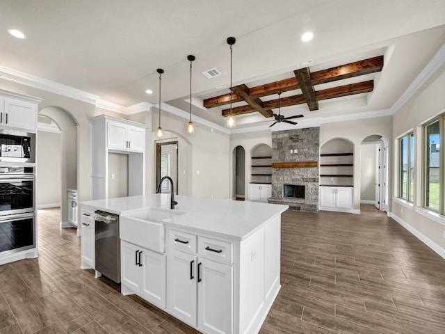 kitchen with white cabinets, a center island with sink, stainless steel appliances, and coffered ceiling