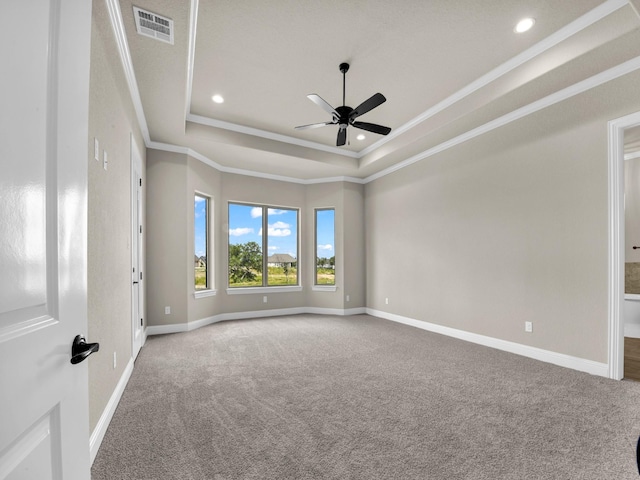 empty room with carpet flooring, ceiling fan, a raised ceiling, and ornamental molding