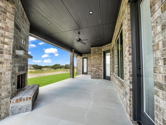 view of patio / terrace with an outdoor stone fireplace and ceiling fan