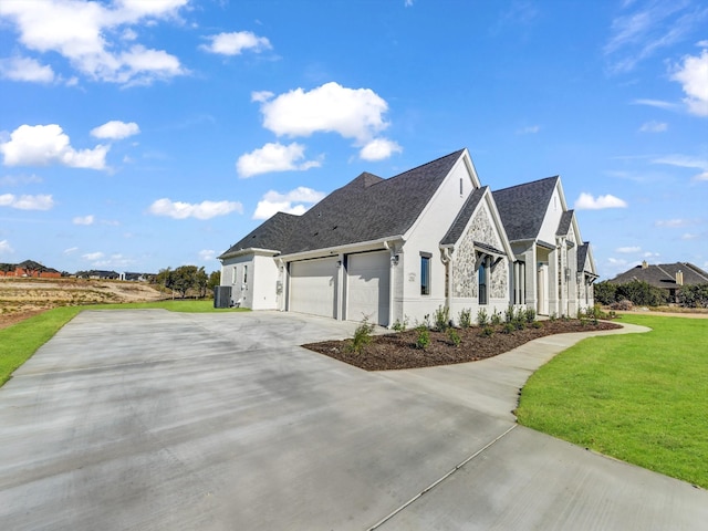 view of side of property featuring a garage and a lawn