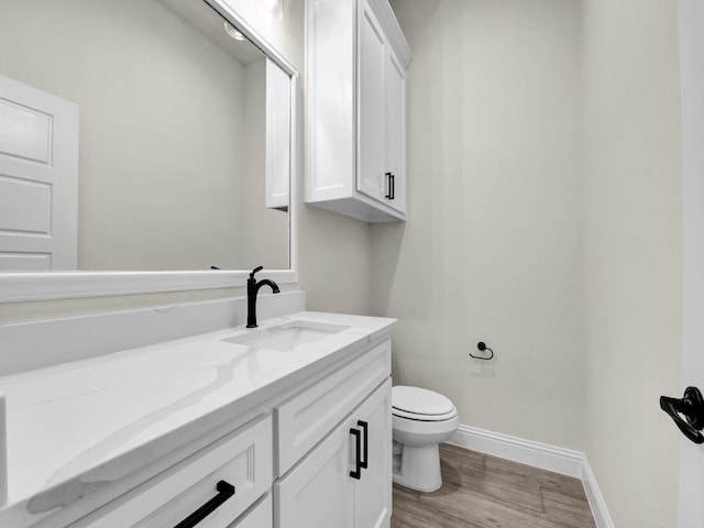 bathroom with hardwood / wood-style floors, vanity, and toilet