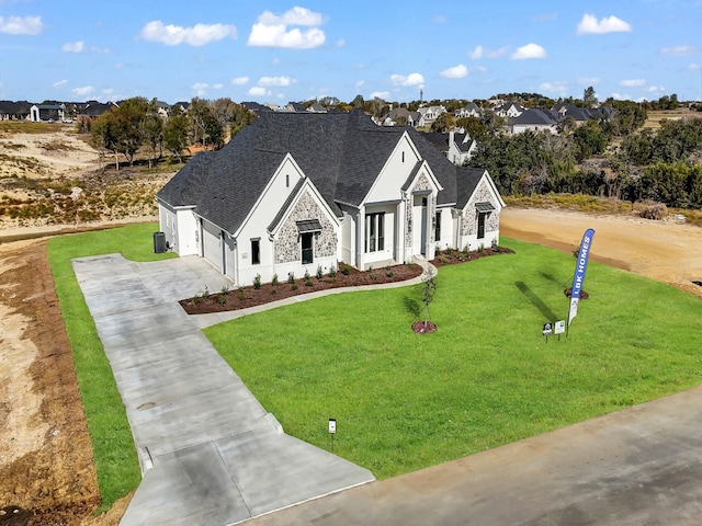 view of front of property with a front yard, central AC, and a garage